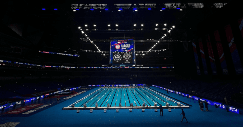 A wide angle view of an Olympic-size swimming pool inside a football stadium.